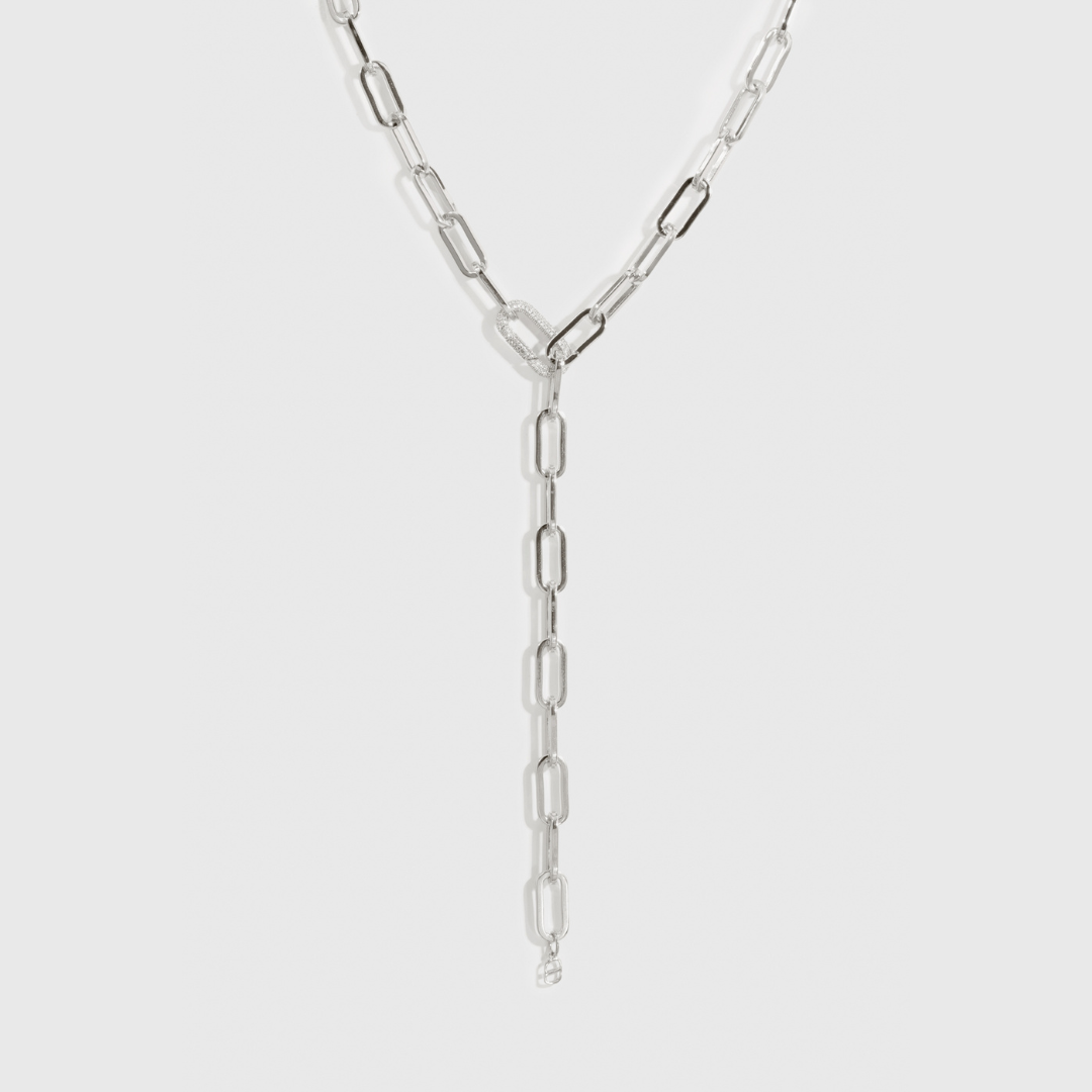 Silver plated maximalist paper clip lariat necklace with a pavé cubic zirconia clasp, shown on a plain background.