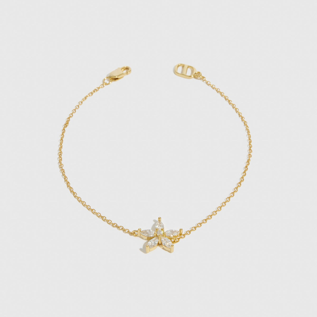 14k gold plated sterling silver 925 flower solitaire bracelet with a pure white cubic zirconia, shown on a plain background.